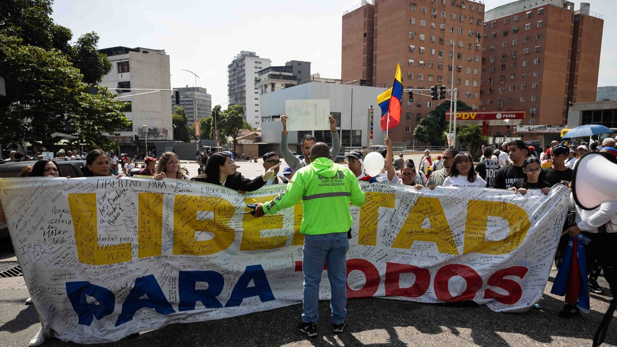 Un funcionario de la Policía Nacional Bolivariana bloquea el paso a familiares de presos políticos durante una protesta alrededor de El Helicoide este sábado 7 de febrero, en Caracas (Venezuela).