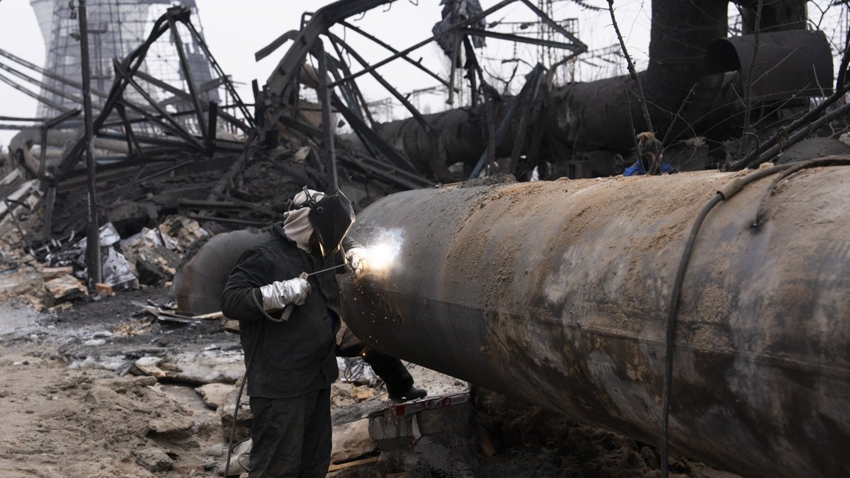 Trabajadores ucranianos reparan una central térmica tras un bombardeo ruso.