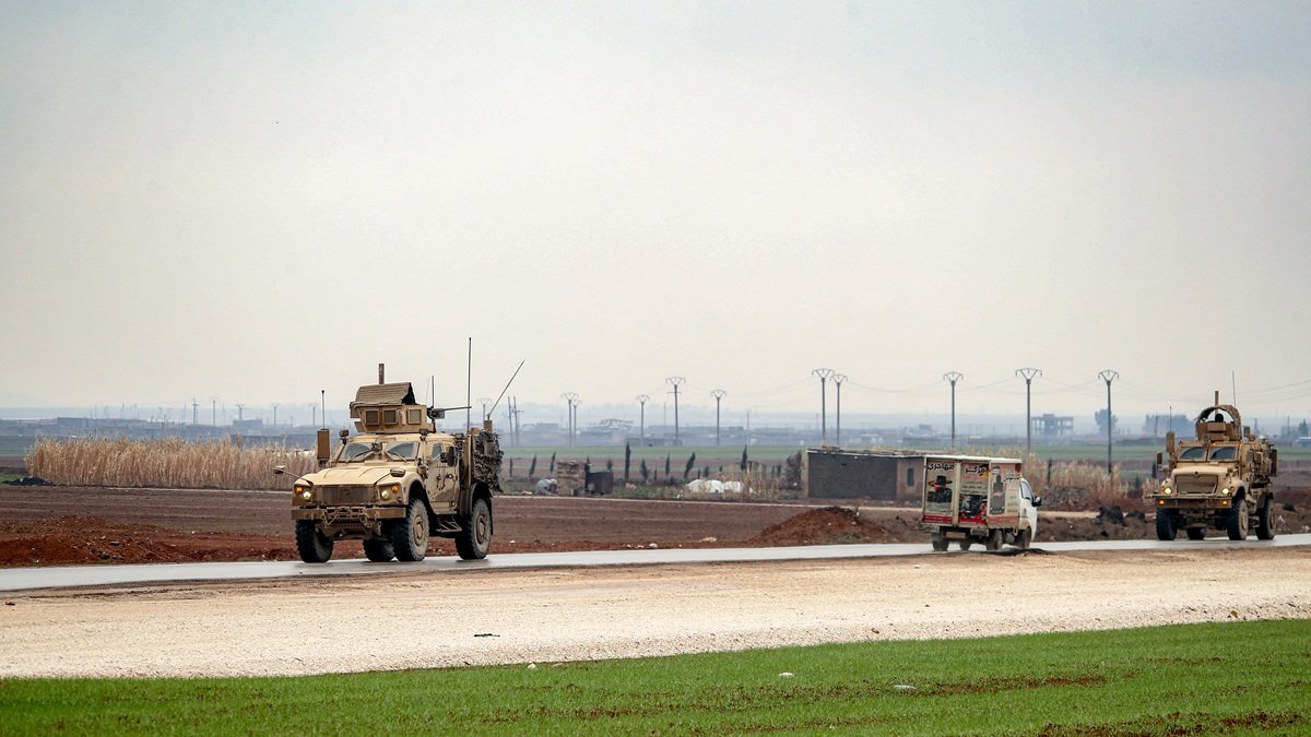 Vehículos militares estadounidenses se mueven por una carretera en un convoy que transporta detenidos del Estado Islámico que son transferidos a Irak desde Siria, este sábado 7 de febrero.