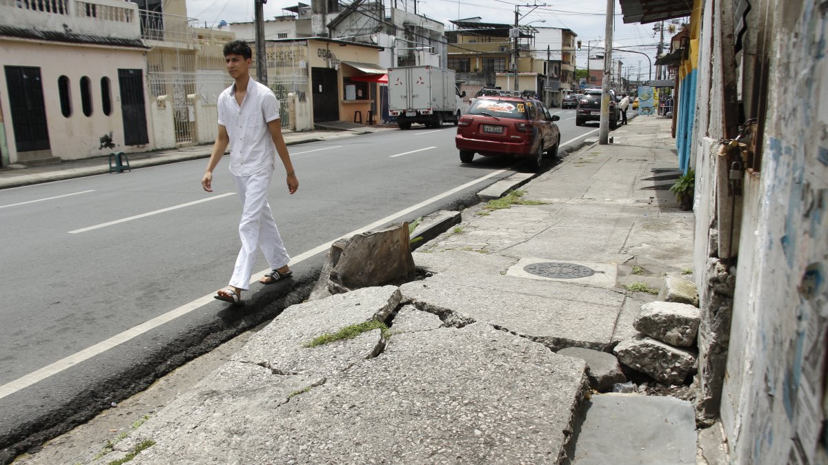 Los peatones deben caminar por la calzada debido al daño en la acera. Ocurre en Lizardo García y Colón, en el sur de Guayaquil.