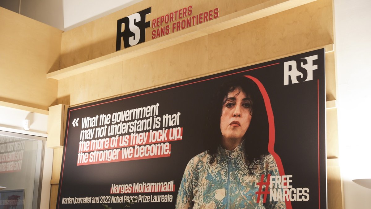 Un cartel muestra el retrato de la periodista iraní y premio nobel de la paz Narges Mohammadi en la sede de Reporteros sin Fronteras en París, Francia.
