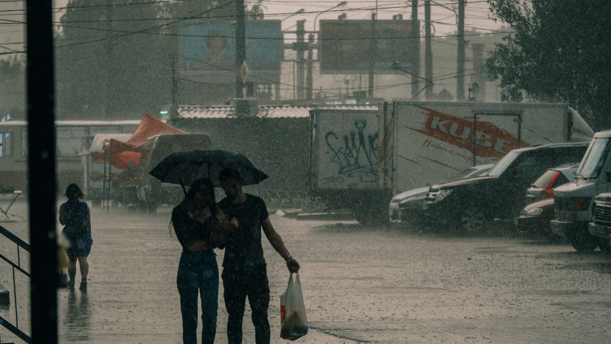 Referencial. Ciudadanos se resguardan bajo paraguas mientras las fuertes lluvias cubren las calles, en medio de la alerta emitida por el Inamhi para varias zonas del país.