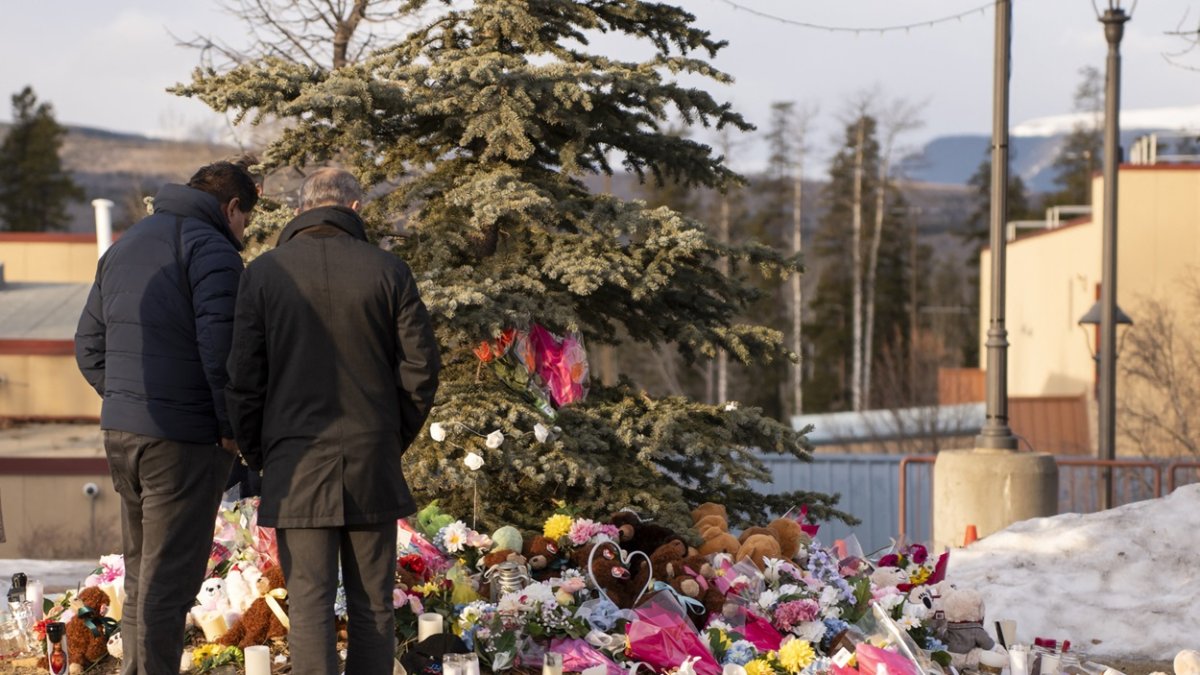La gente trae flores y presenta sus respetos en una vigilia comunitaria en Tumbler Ridge el 12 de febrero de 2026.