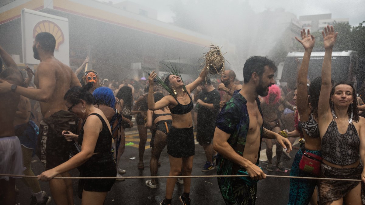 Personas participan en el desfile de la comparsa callejera Fanfarra Manada este sábado 14, en Sao Paulo (Brasil).  