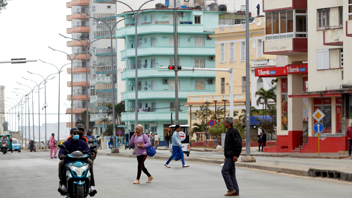 Cubanos transitan por una calle de La Habana en medio de los cambios que permitirán a residentes en el exterior invertir y ser dueños de negocios en la isla.