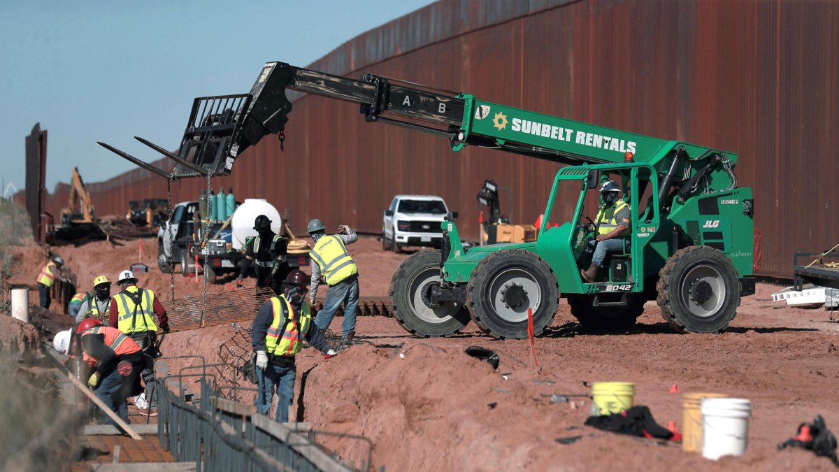Obreros estadounidenses construyen un muro fronterizo, entre El Paso y Ciudad Juárez (México).