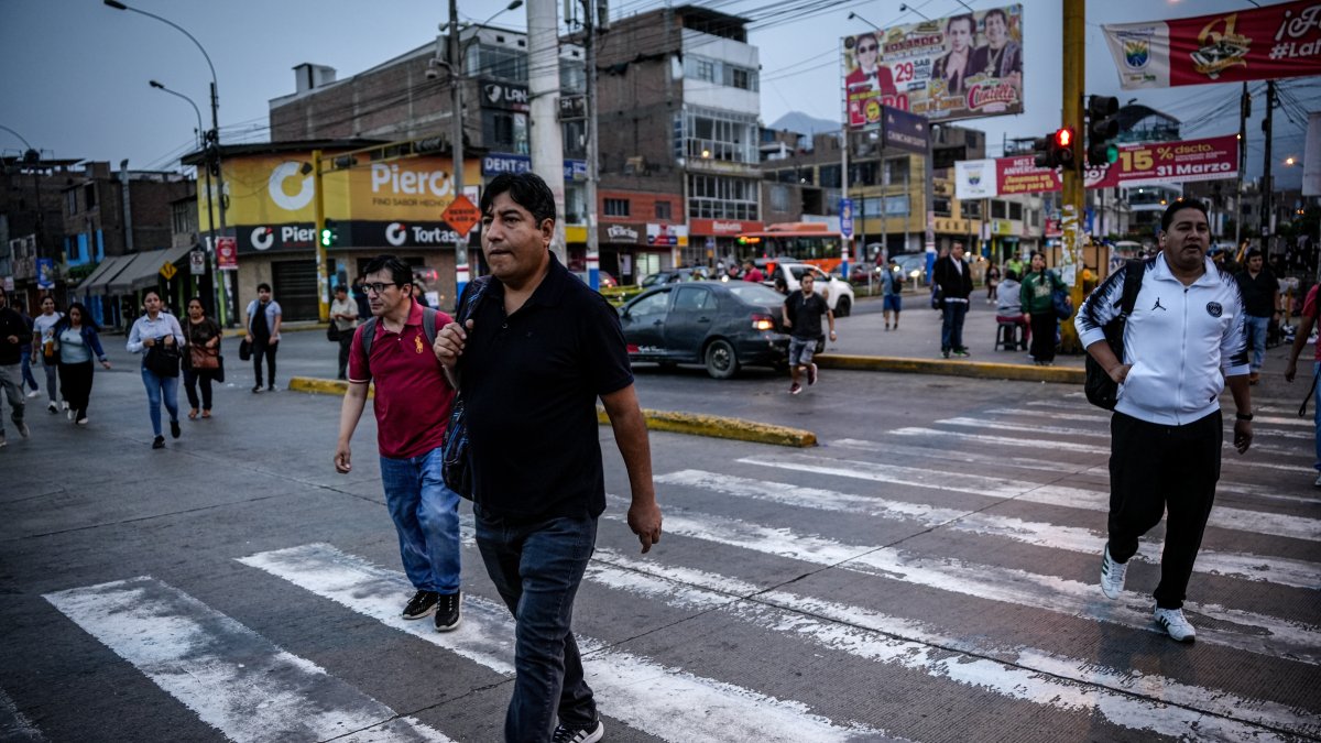 Personas caminan por una avenida en Lima (Perú).