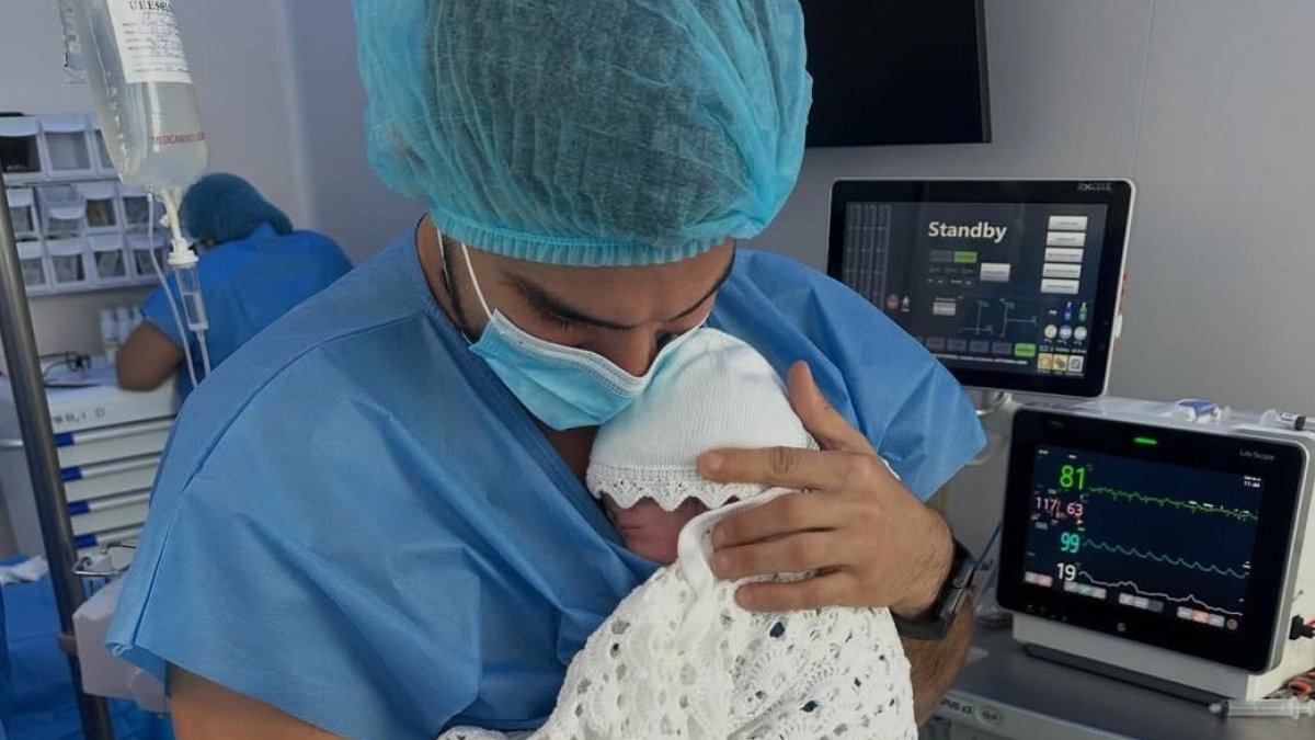 Carlos Scavone lleva en brazos a su hija.