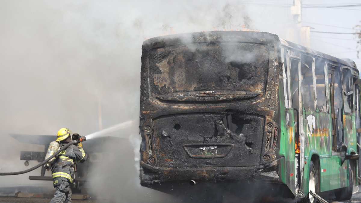 Un integrante del Cuerpo de Bomberos de Guadalajara intenta apagar un vehículo incendiado este domingo 22 de febrero, en esa ciudad mexicana.