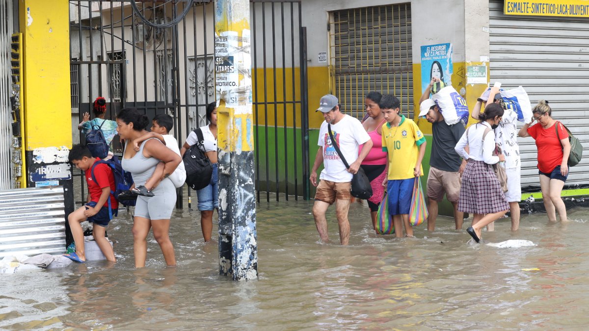 Vías. Las calles y veredas lucen completamente inundadas. Los padres cargan a sus hijos para evitar accidentes.
