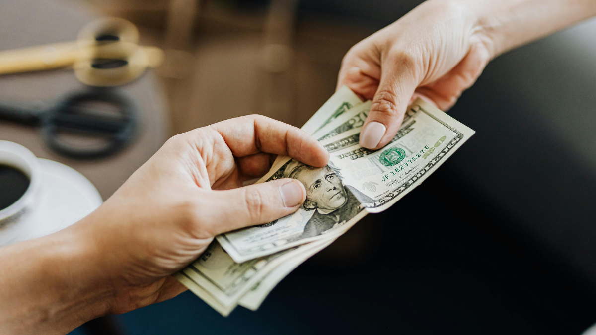 Referencial. La entrega de billetes refleja el pago de obligaciones laborales, como el décimo tercero y cuarto sueldo en Ecuador.