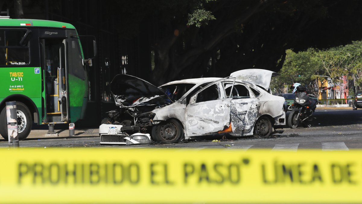 Fotografía que muestra un bloqueo con vehículos incendiados este domingo 22 de febrero, en una vía de Guadalajara (México).