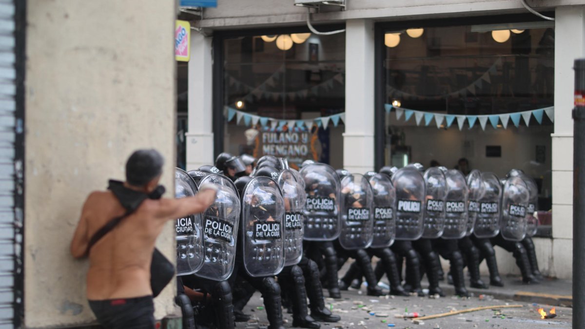 Integrantes de la Policía de Argentina se cubren durante un enfrentamiento con manifestantes por la reforma laboral, en Buenos Aires (Argentina).