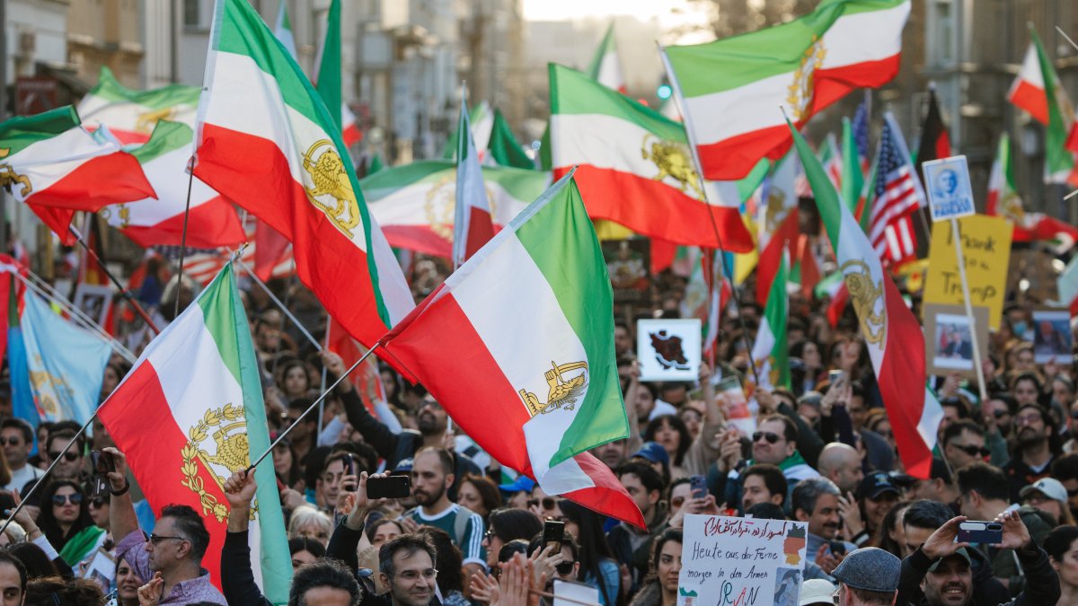 Participantes ondean banderas iraníes prerrevolucionarias durante una manifestación de iraníes exiliados en Berlín, Alemania.
