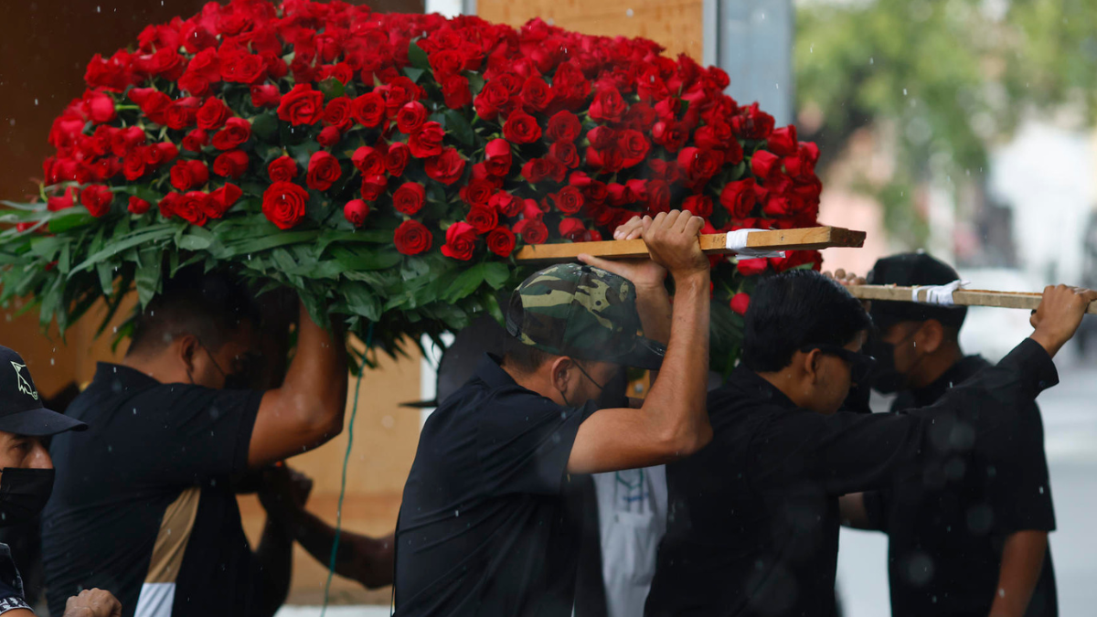 Integrantes del cortejo fúnebre trasladan un arreglo de rosas rojas durante el sepelio de ‘El Mencho’, en medio de un fuerte operativo en Jalisco.
