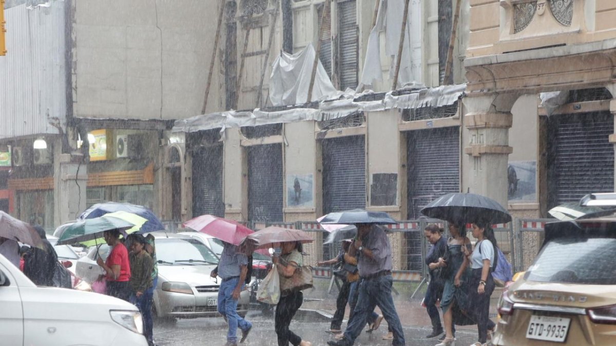 La lluvia en el centro de Guayaquil provocó que las personas busquen resguardarse.