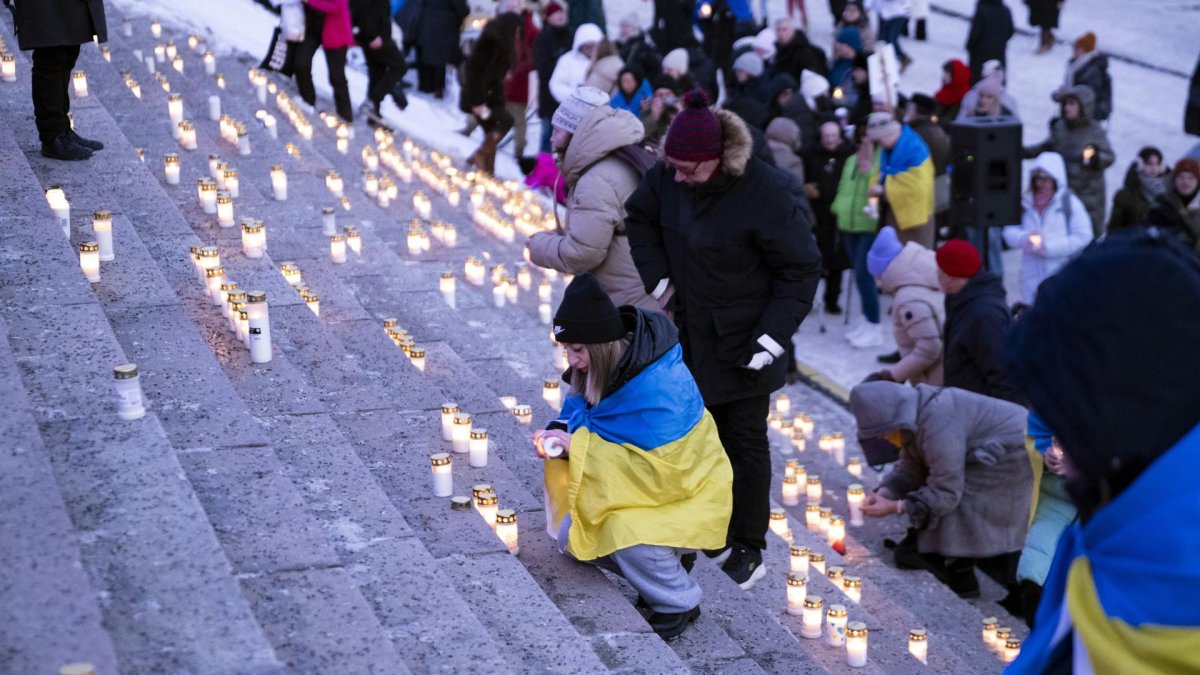 La gente enciende velas durante una manifestación que conmemora el cuarto aniversario de la invasión rusa en Ucrania. Helsinki, Finlandia, el 24 de febrero de 2026.
