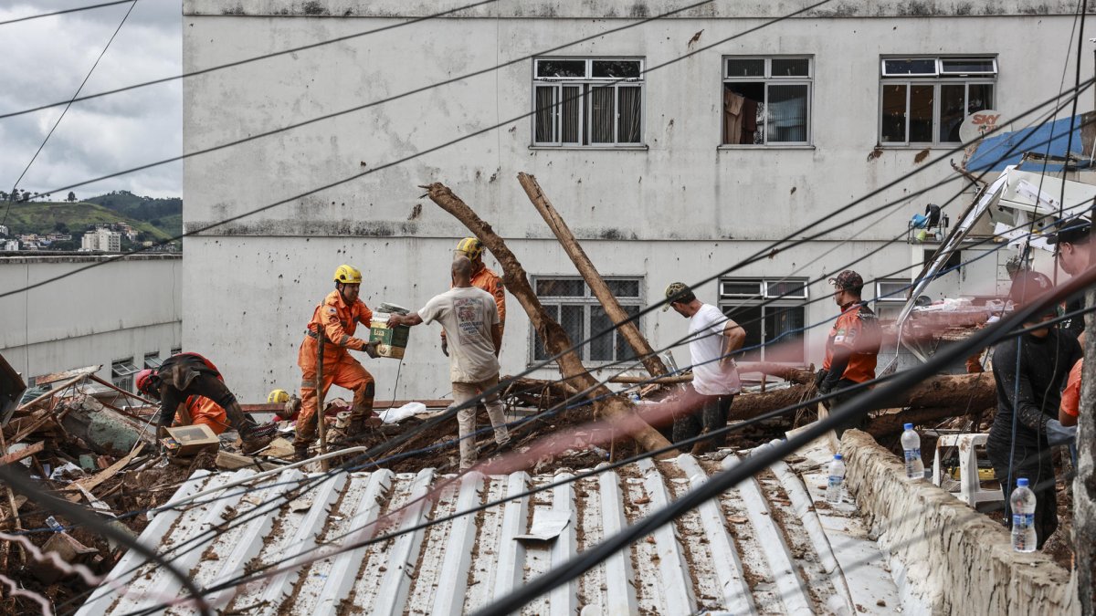 Integrantes del equipo de Bomberos y voluntarios remueven escombros durante las labores de rescate este miércoles, en Juiz de Fora (Brasil).