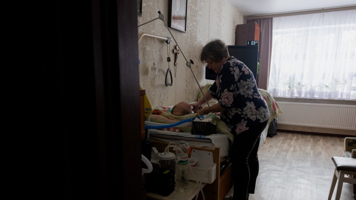 Olena Grygorenko junto a la cama de su esposo Anatoli Kuchynsky en Chernihiv el 12 de febrero de 2026, en medio de la invasión rusa de Ucrania.