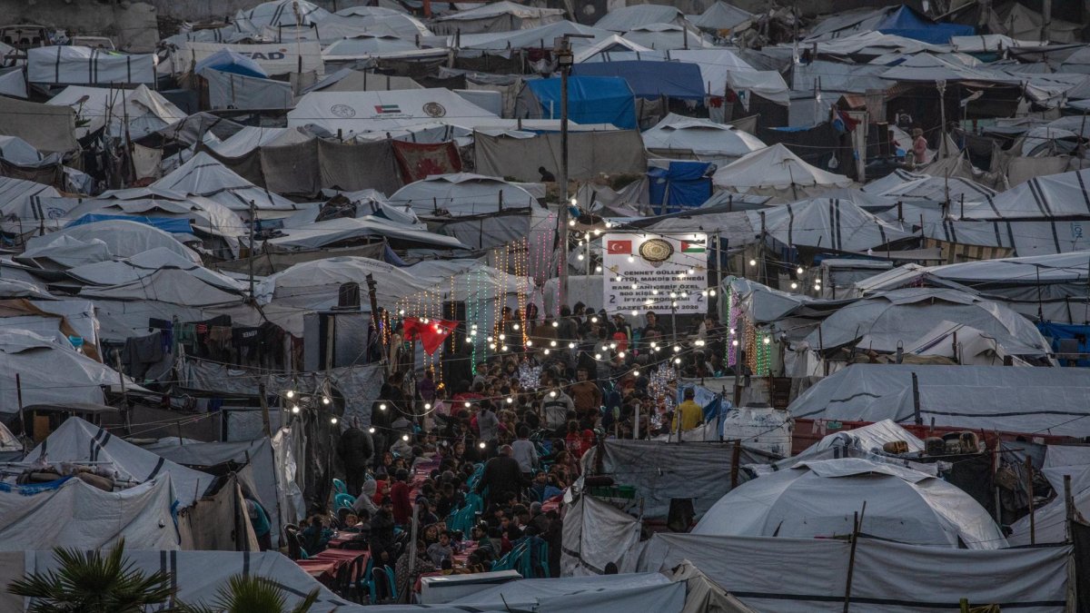 Palestinos desplazados se reúnen entre tiendas de campaña improvisadas para romper el ayuno durante el mes sagrado de ayuno de Ramadán, el 6 de marzo de 2026.