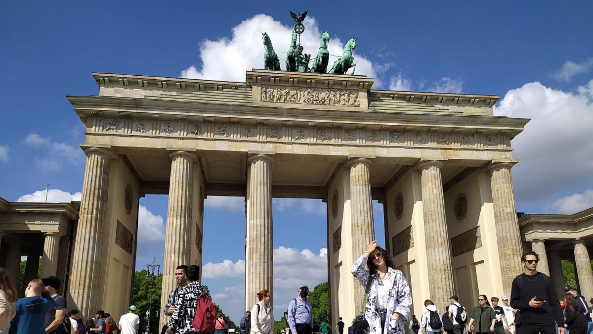 Personas caminan frente a la Puerta de Brandeburgo.