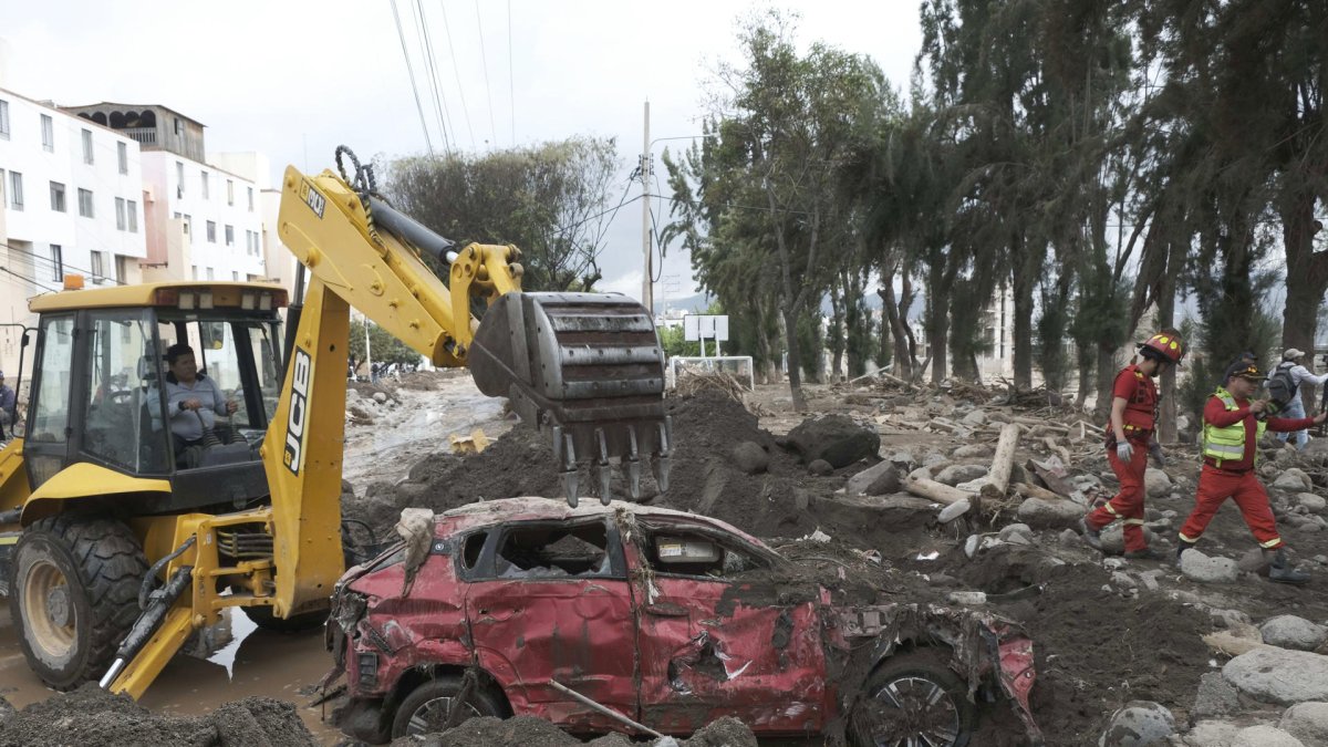 Integrantes del Cuerpo General de Bomberos Voluntarios del Perú inspeccionan una zona afectada por lluvias e inundaciones este lunes, en Arequipa (Perú).