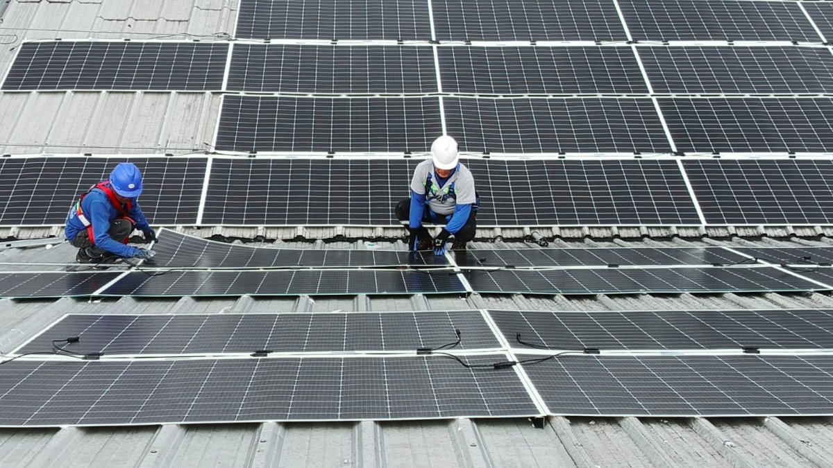 Técnicos de Kubiec S. A. realizan instalaciones de paneles solares en una empresa en Ecuador.