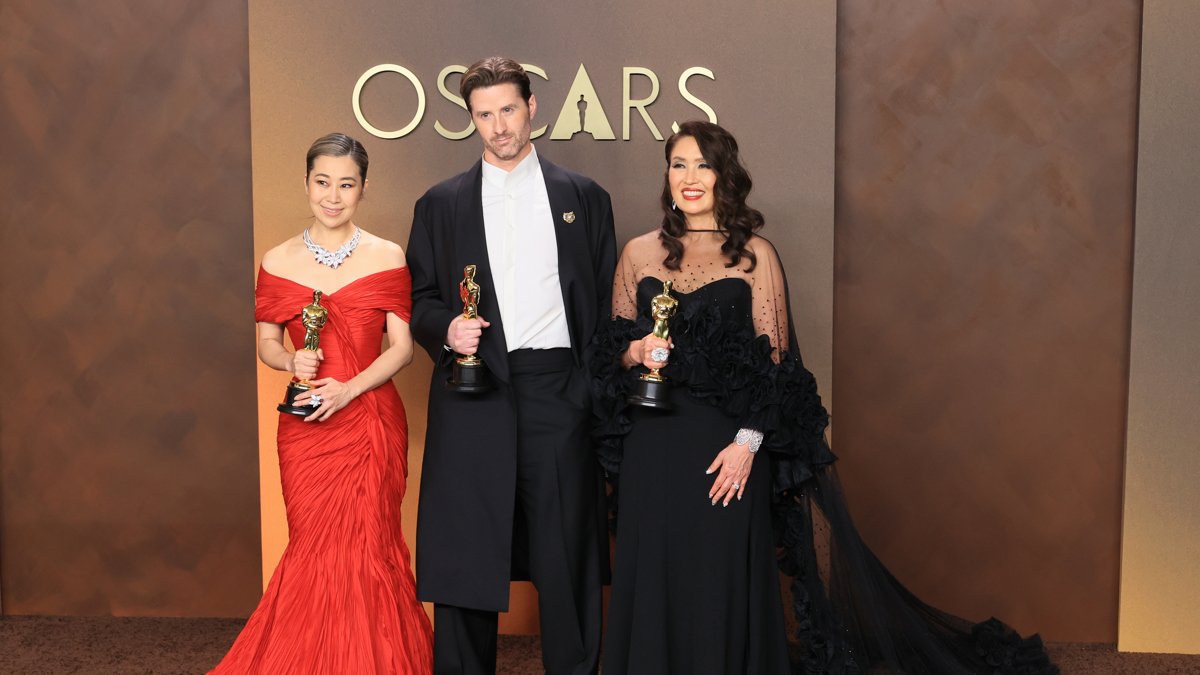 Maggie Kang (i), Chris Appelhans y Michelle L. M. Wong posan con el Óscar a mejor película de animación por K-Pop Demon Hunters este domingo.