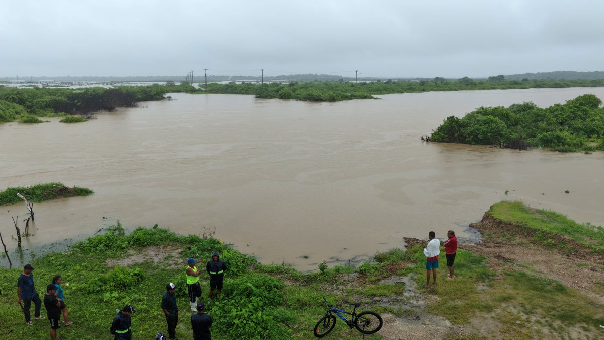 Fotografía aérea que muestra a personas observando las inundaciones en la localidad de Chanduy en Santa Elena.