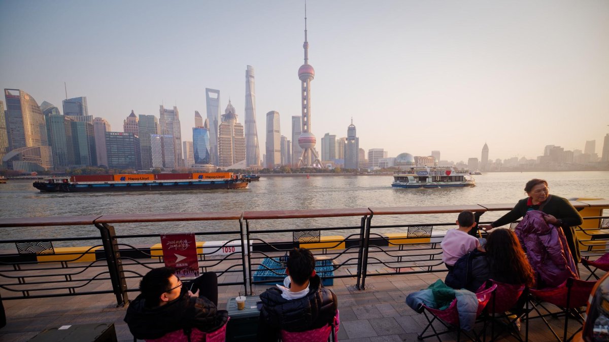 Fotografía de archivo de un grupo de personas frente al paisaje urbano de Shanghai.