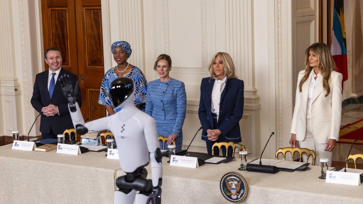 La primera dama de Estados Unidos, Melania Trump, la primera dama de Francia, Brigitte Macron y otros observan mientras un robot pronuncia un discurso en la mesa redonda de la Cumbre 'Fomentando el Futuro Juntos'.