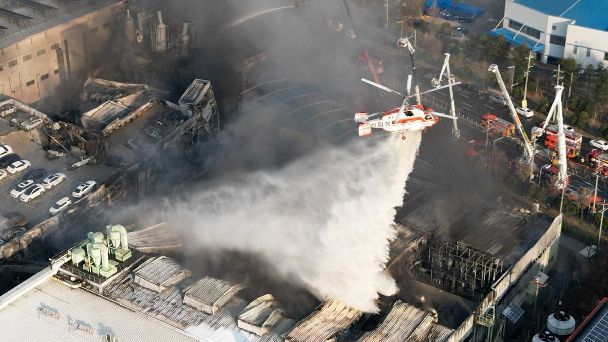 Un helicóptero de extinción de incendios arroja agua para sofocar un incendio en una fábrica de autopartes en Daejeon, el viernes 20 de marzo de 2026.