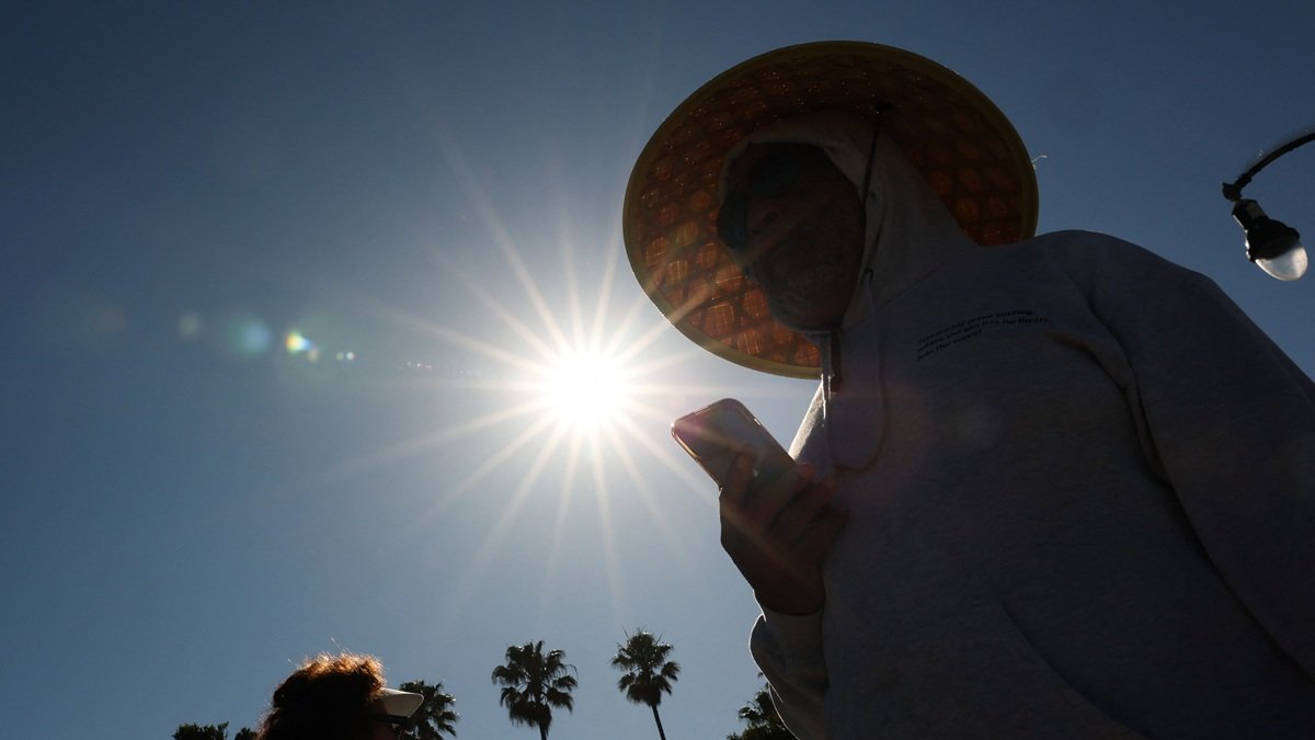 Una persona lleva un sombrero para protegerse del sol matutino mientras camina por The Strand en Redondo Beach, California, el 20 de marzo de 2026, durante una ola de calor.