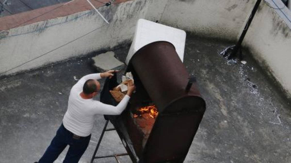 Un hombre quema papeles en la terraza de la Embajada de Cuba en Quito.