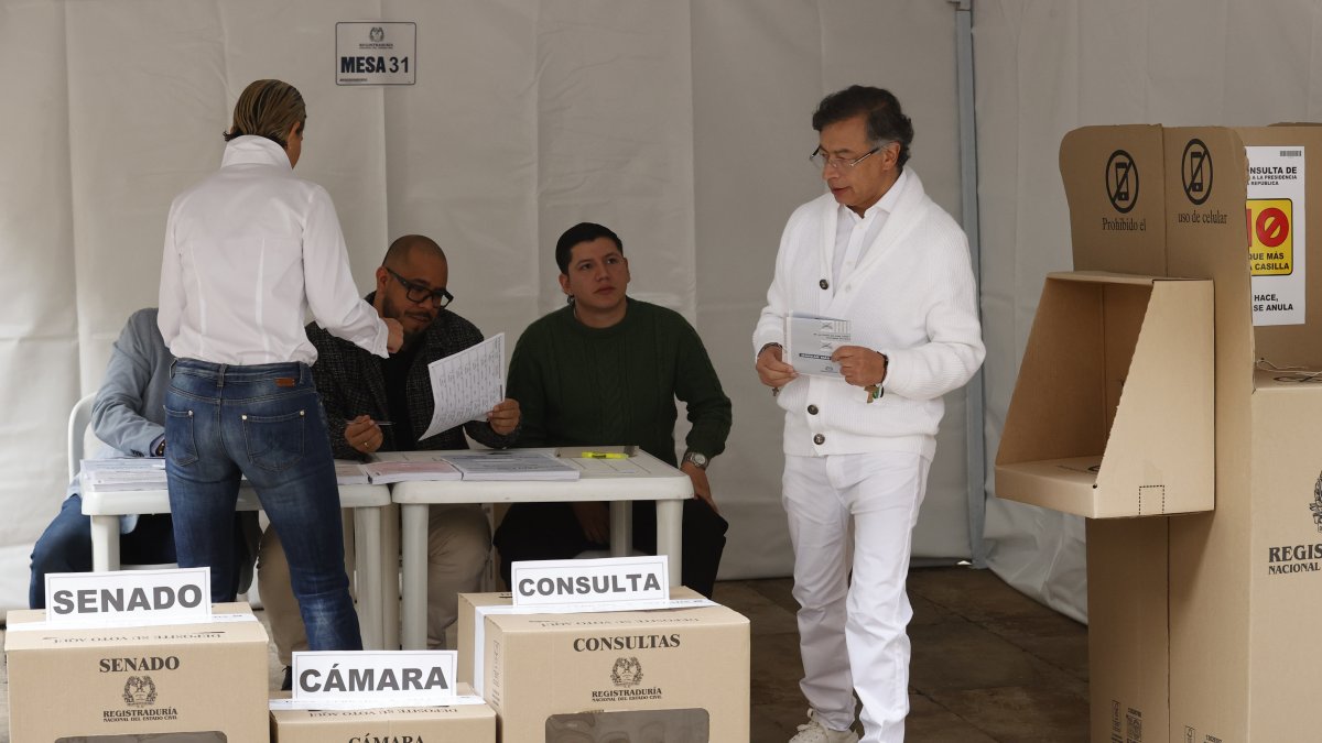 El presidente de Colombia, Gustavo Petro, sostiene las papeletas para Senado y Cámara antes de votar este domingo, en Bogotá.
