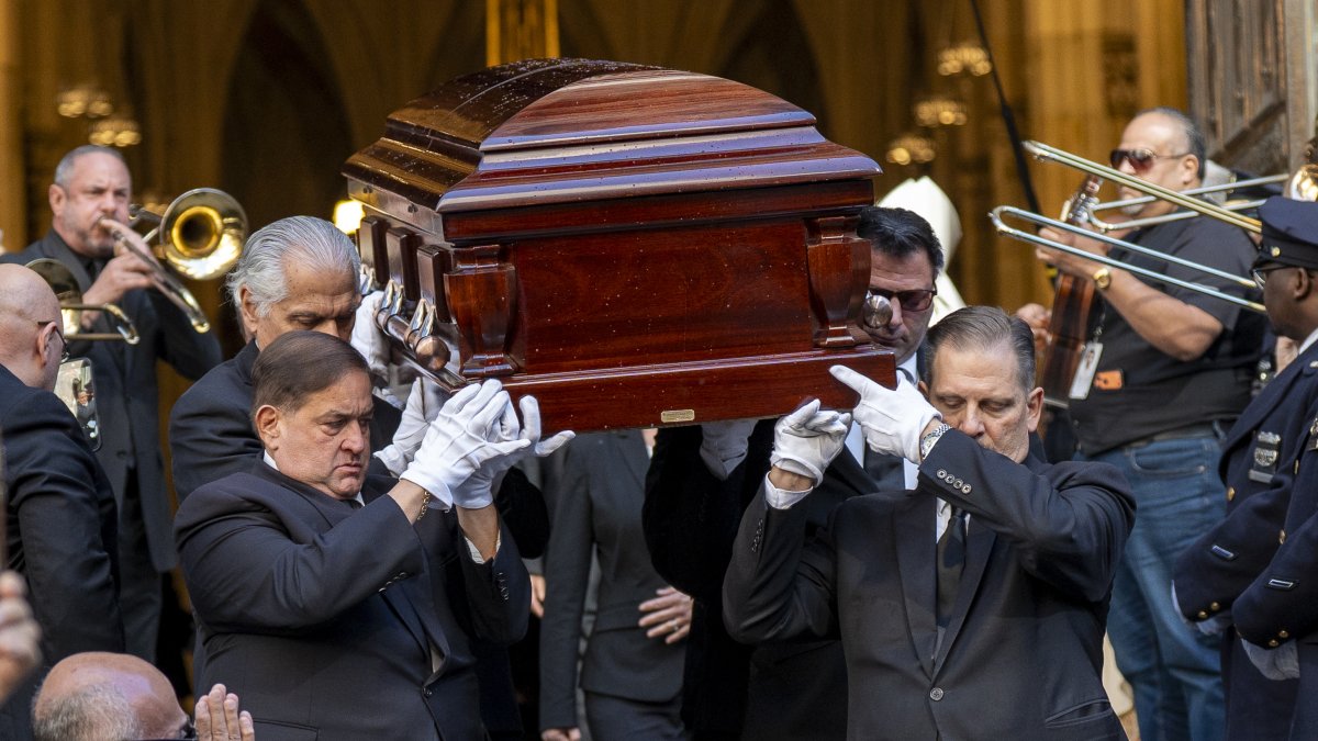 Personas sostienen el féretro del cantante Willie Colón este lunes, al finalizar una misa pública con motivo de su funeral en la Catedral de San Patricio en Nueva York.