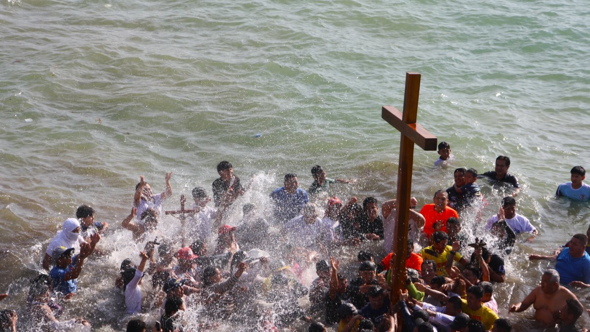 Entre plegarias y cánticos los pescadores de Ballenita bañaron la cruz