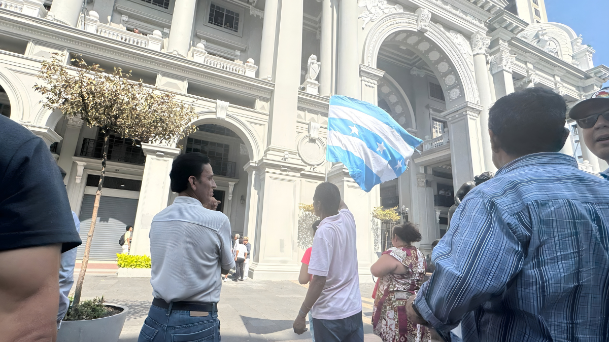 Ciudadanos permanecen en los exteriores del Municipio de Guayaquil durante el allanamiento ejecutado por la Fiscalía, en el marco de una investigación por presunta falsificación de documentos.