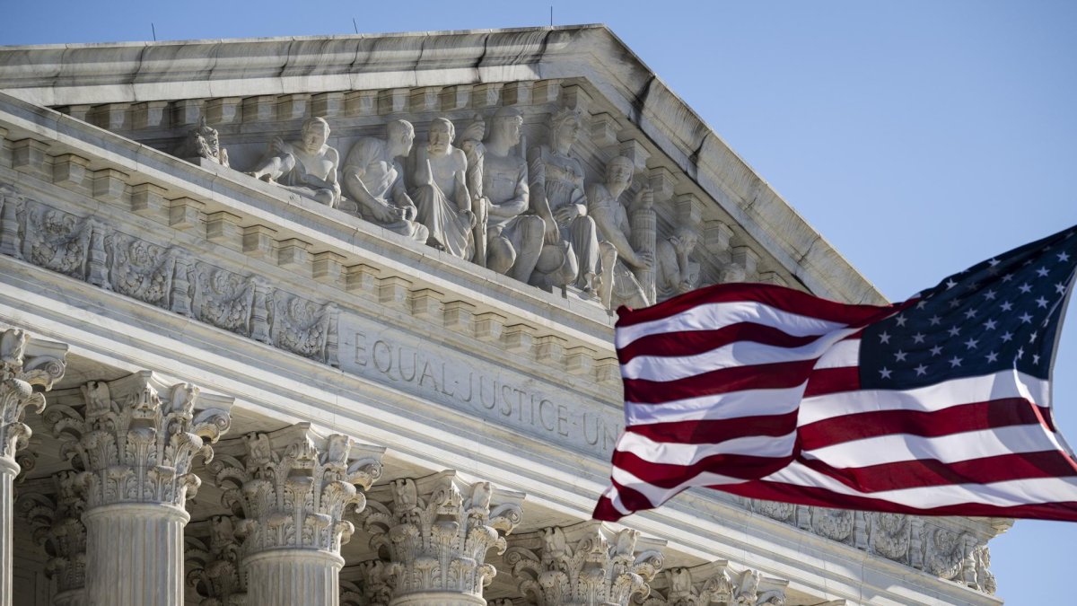 Foto que muestra una bandera estadounidense ondeando frente a la Corte Suprema de Estados Unidos en Washington D. C.