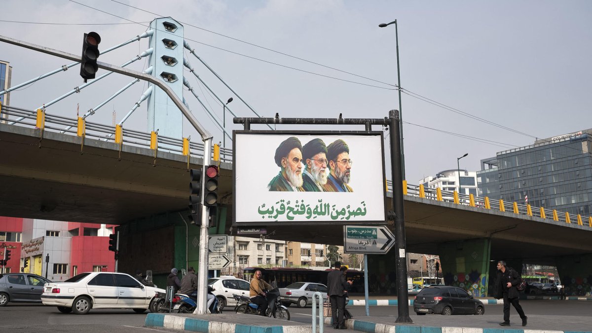 Un cartel muestra al nuevo líder supremo de Irán, Mojtaba Jameneí, junto con su padre y antecesor Alí Jameneí y el fundador de la República Islámica Ruholá Jomeiní en el norte de Teherán.