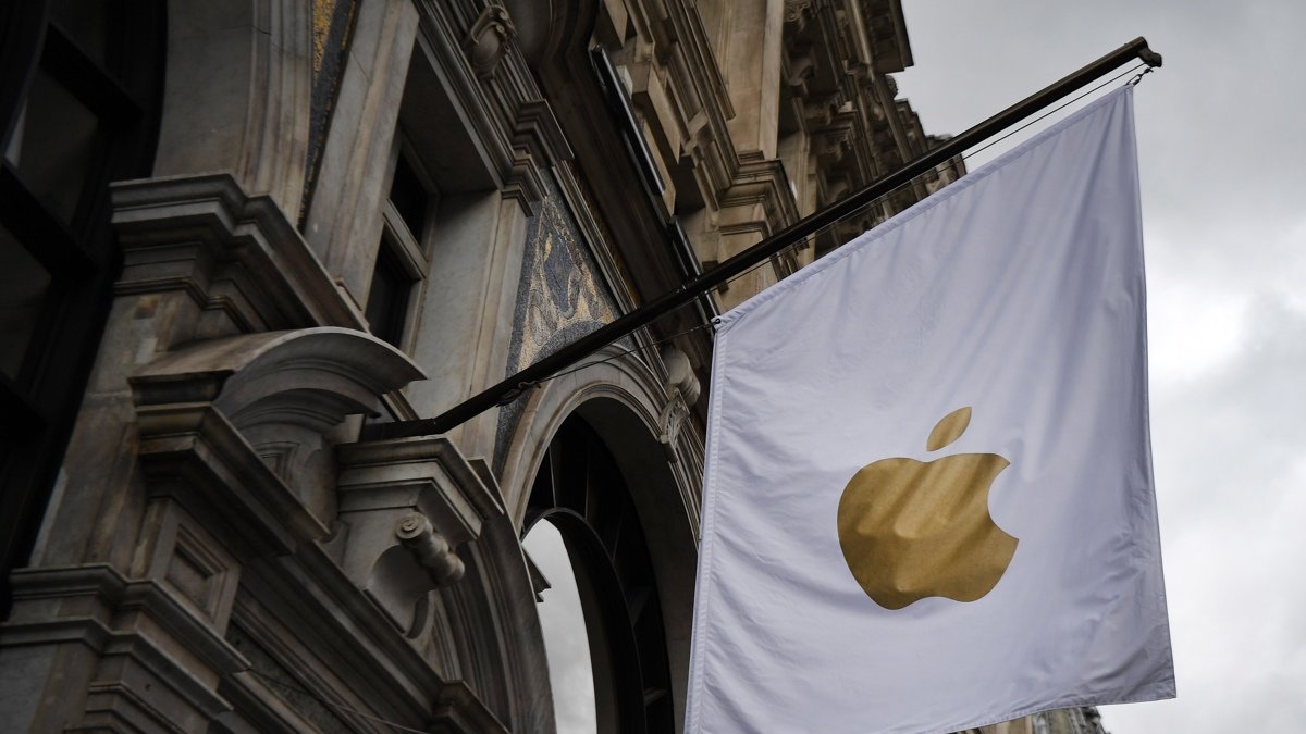 Una bandera con el símbolo de Apple decora el exterior de una tienda.