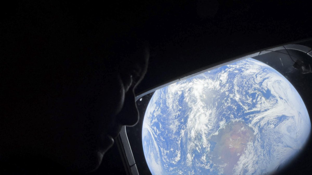 El comandante Reid Wiseman observa la Tierra mientras continúan adentrándose en el espacio hacia la Luna.