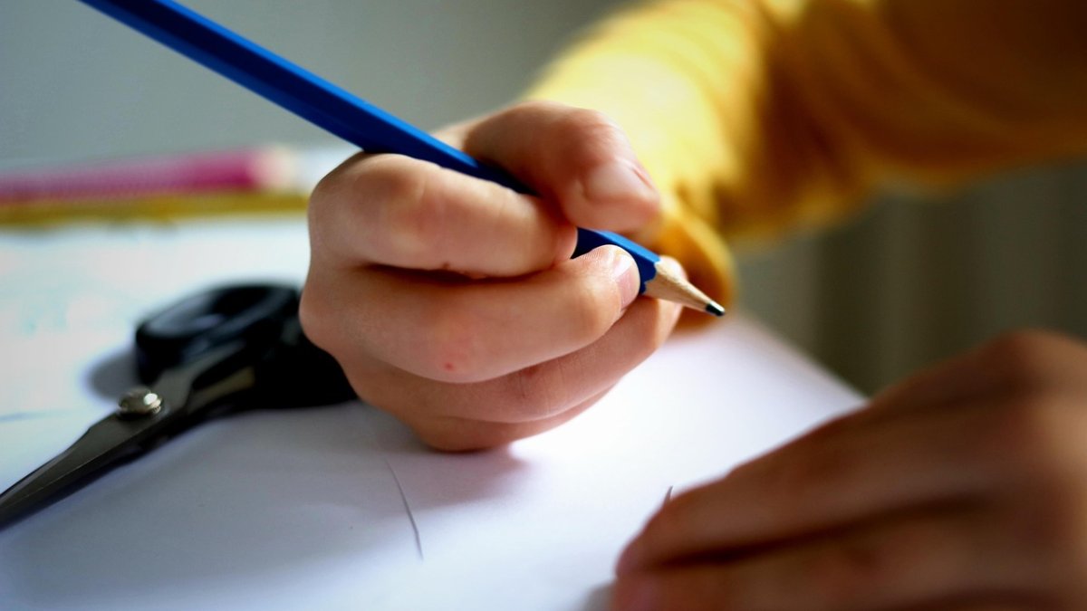 Imagen referencial de un niño escribiendo.