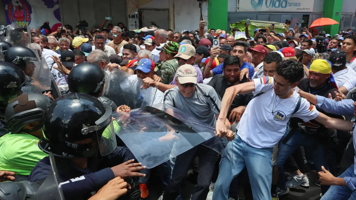 Personas exigen aumentos salariales mientras se enfrentan con integrantes de la policía en una manifestación este jueves, en Caracas (Venezuela).