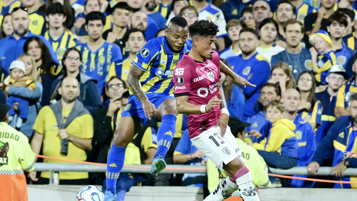 Jáminton Campaz (i) de Rosario disputa un balón con Daykol Romero de Independiente del Valle .