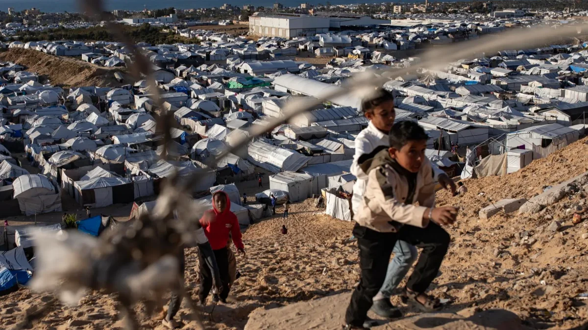Niños palestinos desplazados juegan junto a sus tiendas de campaña dentro de un campamento de refugio temporal instalado en el sur de la Franja de Gaza.
