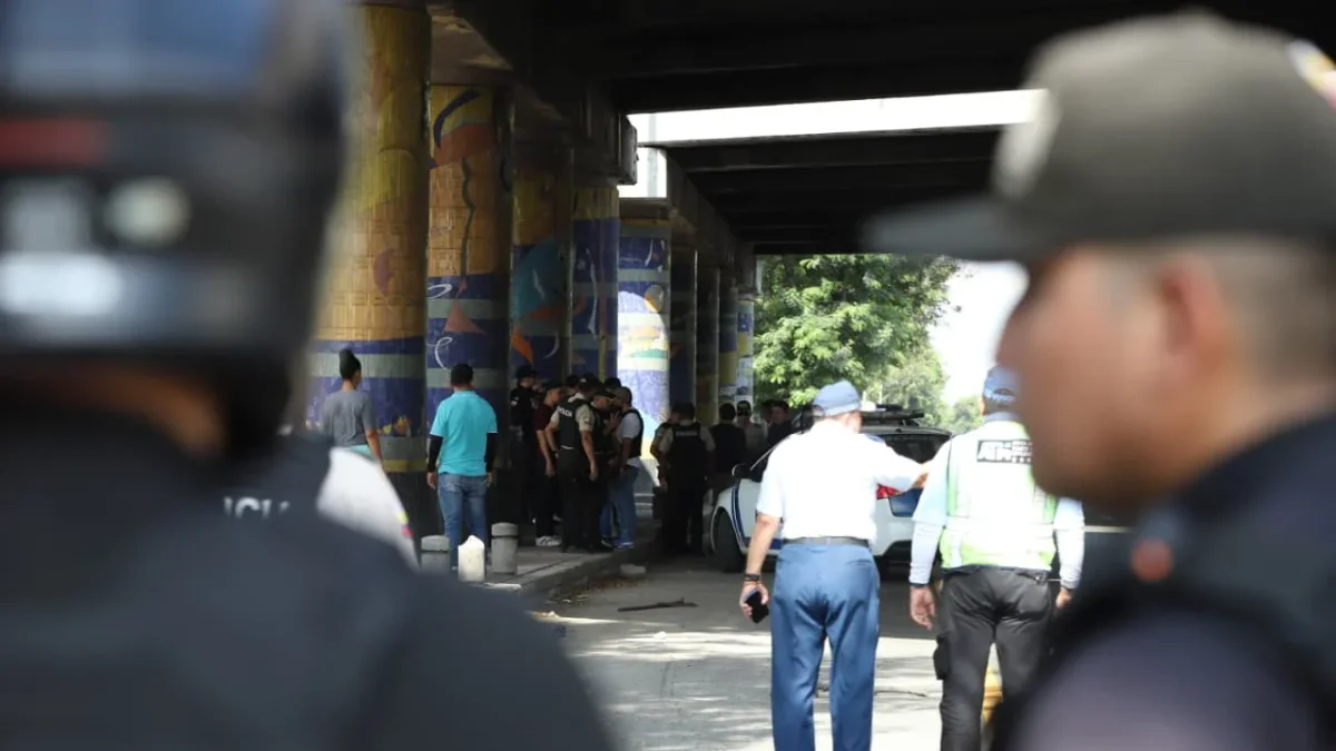 Policías y agentes de tránsito inspeccionan la escena del ataque armado en la vía a la costa, en Guayaquil, donde dos uniformados fueron asesinados tras una persecución desde Santa Elena.
