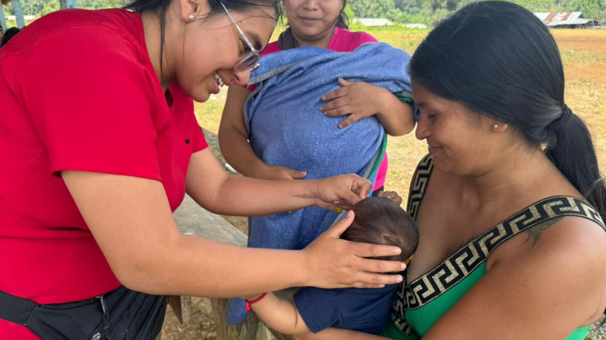 Médica aplica dosis de vacunas a un bebé, en una población de Ecuador.