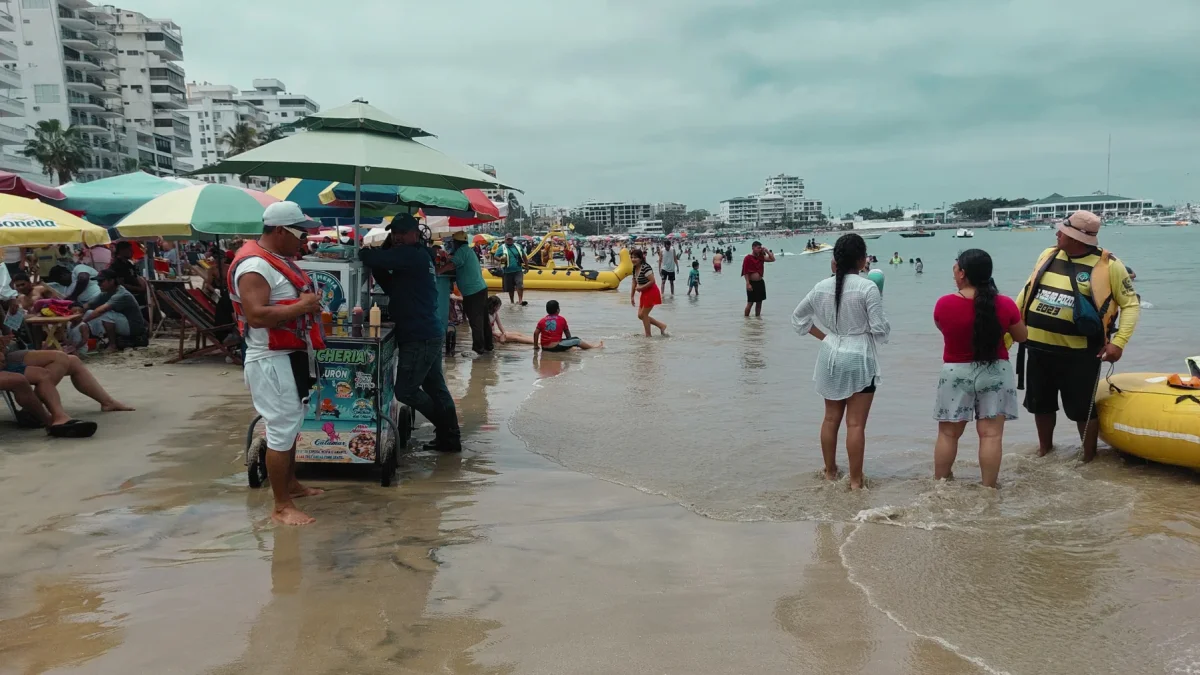 Turistas y locales disfrutan de un día de playa durante un feriado en la costa de Ecuador.