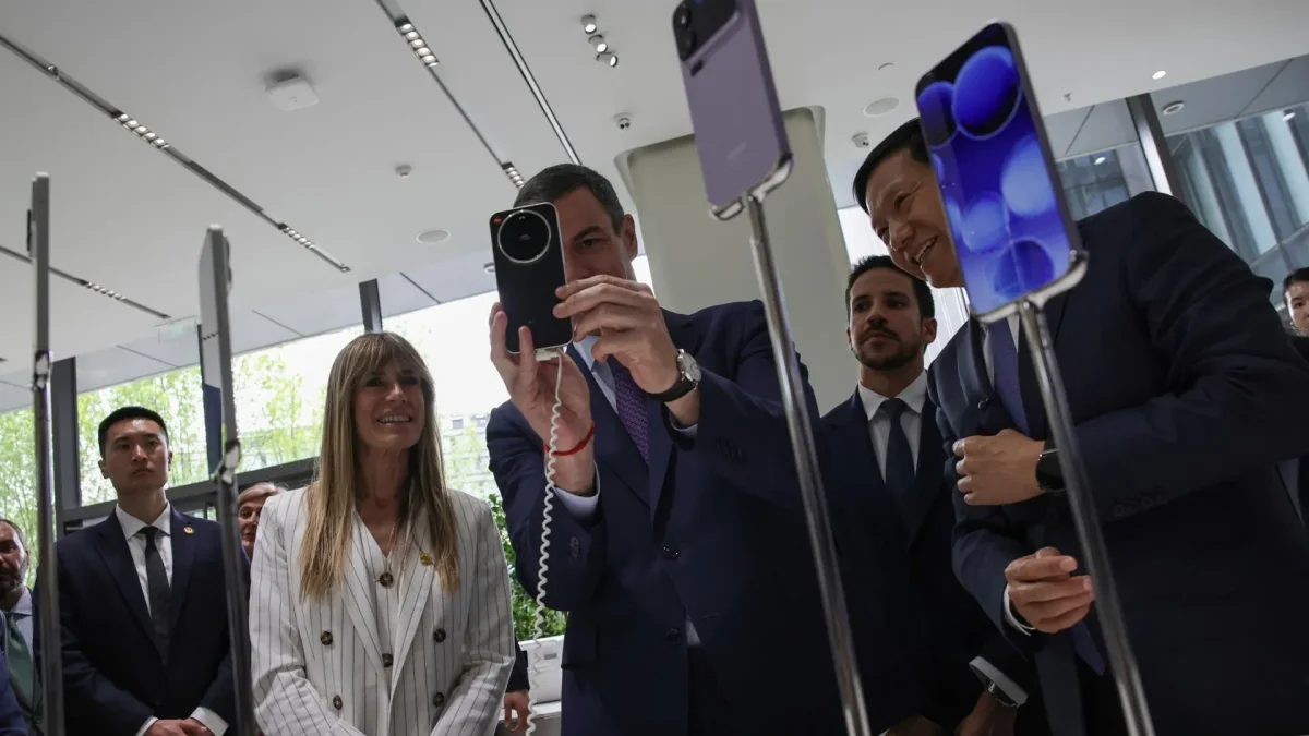 El presidente del Gobierno español, Pedro Sánchez), se toma una foto con un teléfono inteligente Xiaomi en presencia de su esposa, Begoña Gómez, en Pekín, el 13 de abril de 2026.